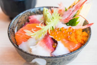 Üstte sashimi deniz ürünleri ile Japon pirinç kase
