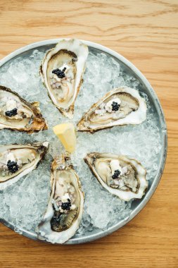 Ham ve taze istiridye havyar üstte ve limon ile