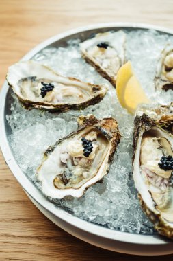 Ham ve taze istiridye havyar üstte ve limon ile