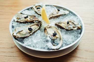 Ham ve taze istiridye havyar üstte ve limon ile