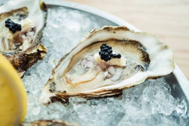 Ham ve taze istiridye havyar üstte ve limon ile