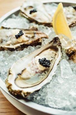 Ham ve taze istiridye havyar üstte ve limon ile