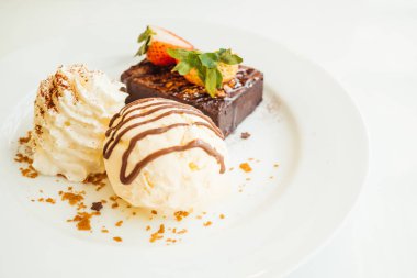 Vanilyalı dondurma ile Çikolatalı browni kek üzerinde çilek ile