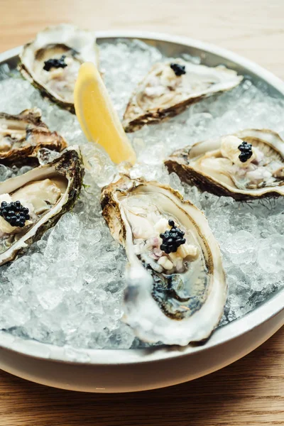 Raw and fresh Oyster with caviar on top and lemon — Stock Photo, Image