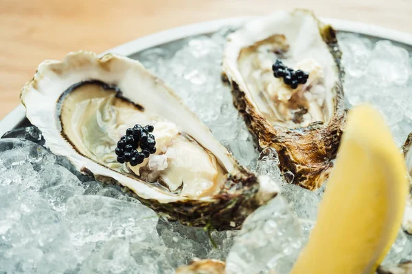 Raw and fresh Oyster with caviar on top and lemon — Stock Photo, Image