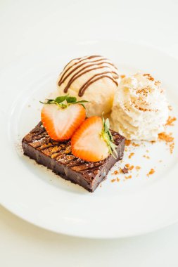 Vanilyalı dondurma ile Çikolatalı browni kek üzerinde çilek ile
