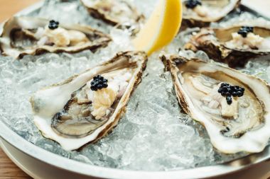 Ham ve taze istiridye havyar üstte ve limon ile