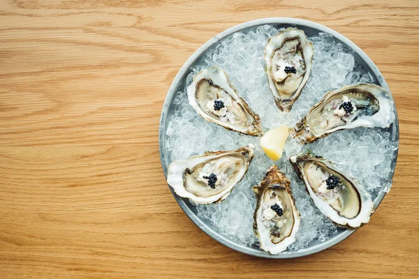 Raw and fresh Oyster with caviar on top and lemon — Stock Photo, Image