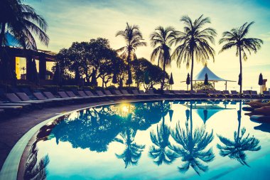 Siluet Hindistan cevizi hurma ağacının Yüzme Havuzu etrafında