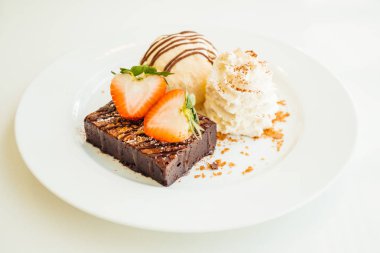 Vanilyalı dondurma ile Çikolatalı browni kek üzerinde çilek ile