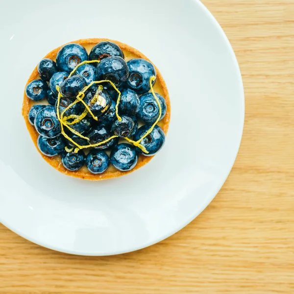 Sweet dessert with blueberry tart in white plate — Stock Photo, Image