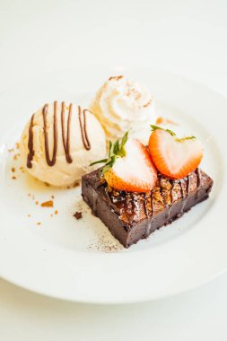 Vanilyalı dondurma ile Çikolatalı browni kek üzerinde çilek ile