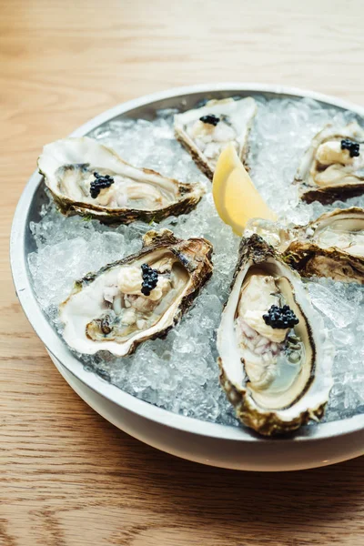 Raw and fresh Oyster with caviar on top and lemon — Stock Photo, Image