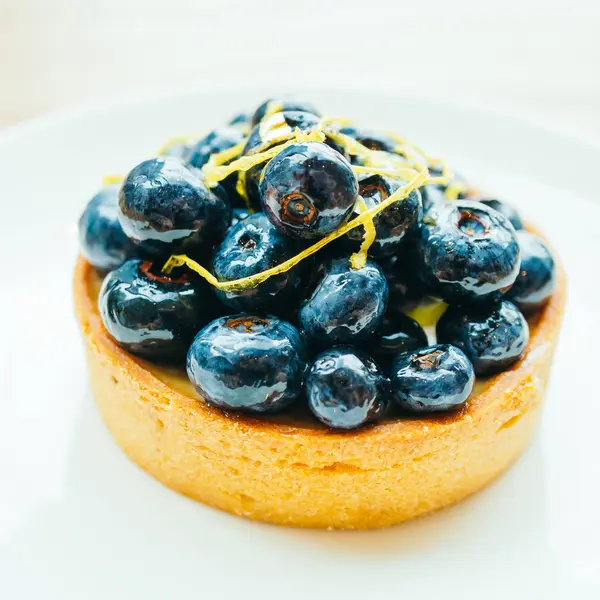 흰색 접시에 블루베리 타트와 달콤한 디저트 — 스톡 사진