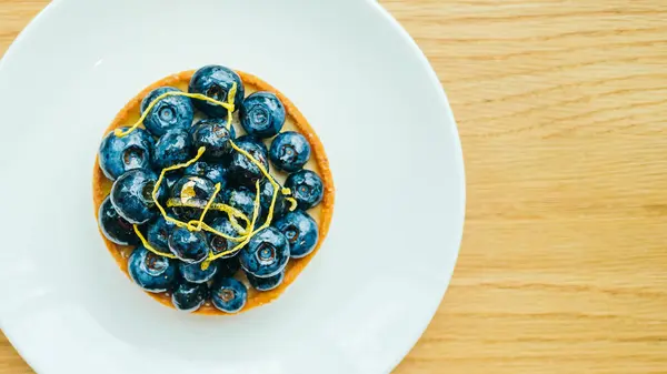 Sweet dessert with blueberry tart in white plate — Stock Photo, Image