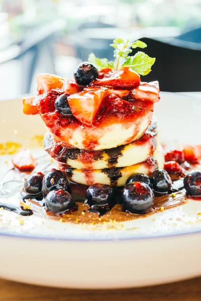 Pancakes with mixed berry fruit in white plate