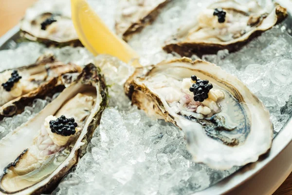 Ostra cruda y fresca con caviar encima y limón — Foto de Stock