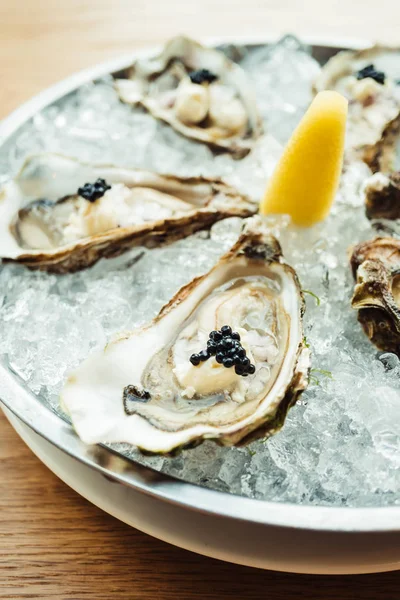 Raw and fresh Oyster with caviar on top and lemon — Stock Photo, Image