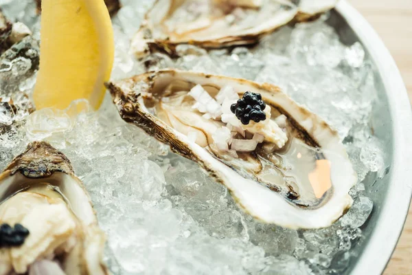 Raw and fresh Oyster with caviar on top and lemon — Stock Photo, Image