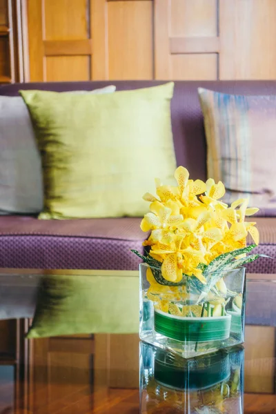 Vase flower on table with pillow on sofa