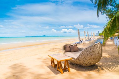 Sandalye ve masa üzerinde plaj ve deniz mavi gökyüzü ile yemek