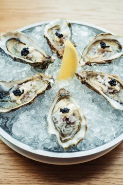 Ham ve taze istiridye havyar üstte ve limon ile