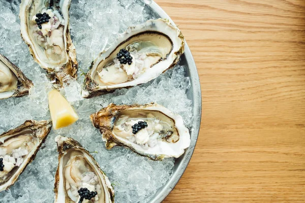 Raw and fresh Oyster with caviar on top and lemon — Stock Photo, Image