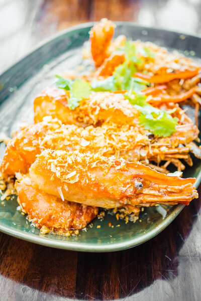 Жареные креветки с чесноком в тарелке
