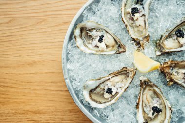 Ham ve taze istiridye havyar üstte ve limon ile