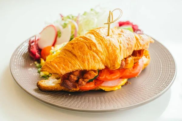 Sahanda yumurta ve sebze ve kruvasan sandviç gevrek domuz pastırması jambon peynir içinde - renk filtresi işleme ile kahvaltı tabağı