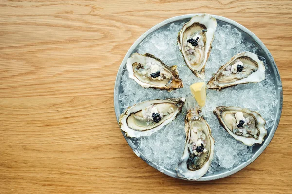 Ostra cruda y fresca con caviar encima y limón — Foto de Stock