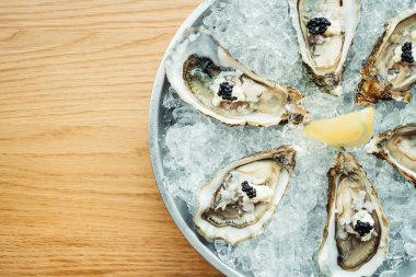 Ham ve taze istiridye havyar üstte ve limon ile 