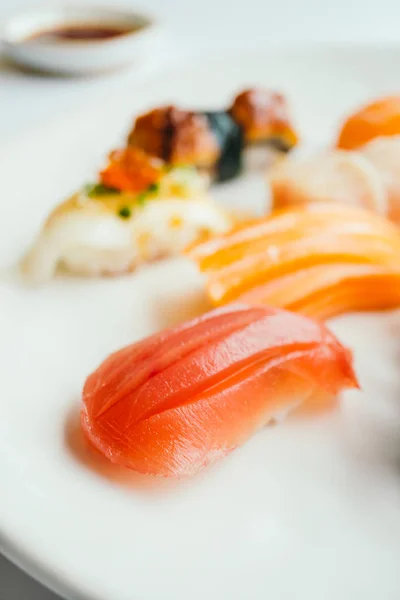 Sushi nigiri crudo y fresco engastado en plato blanco —  Fotos de Stock