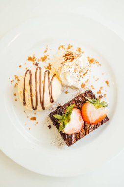 Vanilyalı dondurma ile Çikolatalı browni kek üzerinde çilek ile