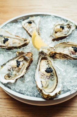 Ham ve taze istiridye havyar üstte ve limon ile 