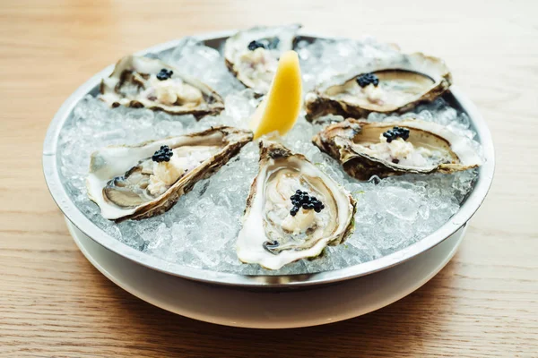 Raw and fresh Oyster with caviar on top and lemon — Stock Photo, Image