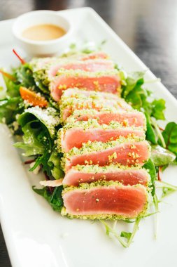 Ham ve taze orkinos et beyaz plaka - sağlıklı gıda tarzı sebze salatası ile