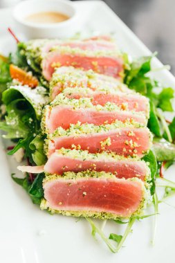 Ham ve taze orkinos et beyaz plaka - sağlıklı gıda tarzı sebze salatası ile