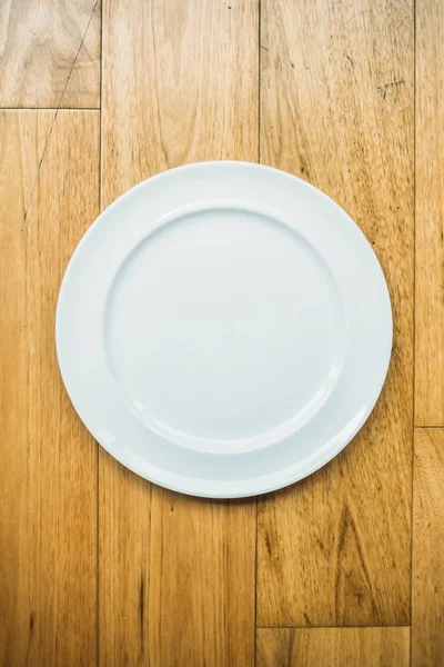 Pusty biały talerz na drewnianym tle — Zdjęcie stockowe