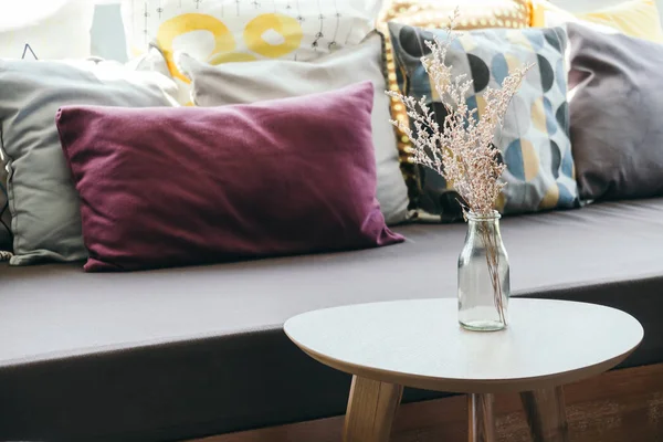 Цветочная ваза для украшения стола подушкой и диваном — стоковое фото