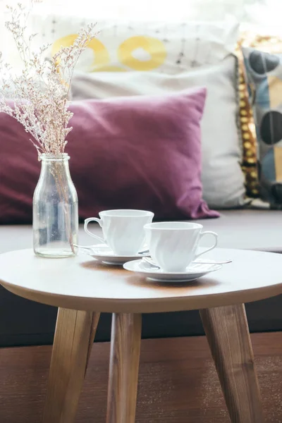 Біла чашка кави з квітковою вазою на столі прикраса з пілло — стокове фото