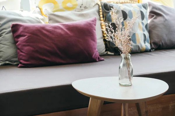 Vase de fleurs sur la décoration de table avec oreiller et canapé — Photo