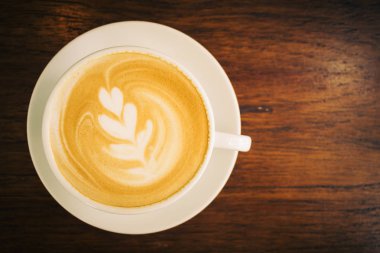 Restoran ve kafeterya masada beyaz fincan sıcak latte kahve