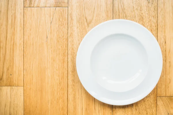 Ahşap zemin üzerinde boş beyaz tabak