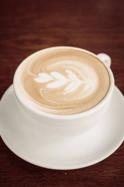 Restoran ve kafeterya masada beyaz fincan sıcak latte kahve