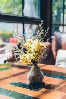 Masasında çiçekler olan vazo.