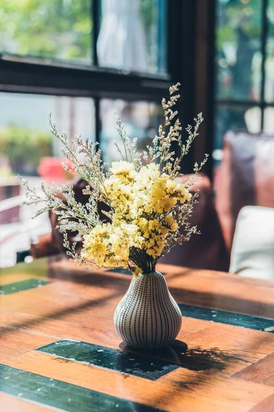 Masasında çiçekler olan vazo.