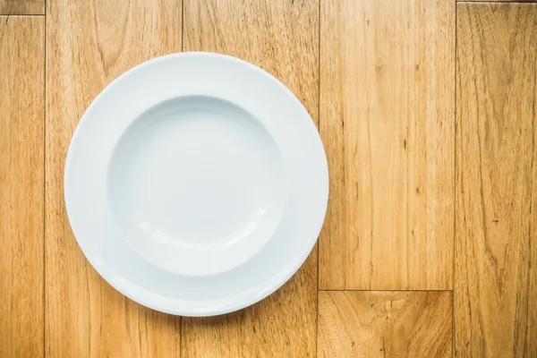 Empty white plate on wooden background — Stock Photo, Image