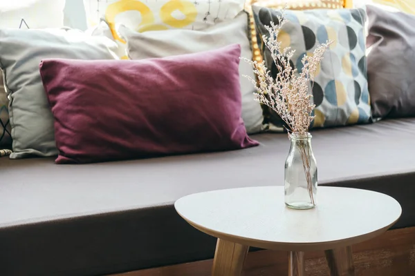 Vase de fleurs sur la décoration de table avec oreiller et canapé — Photo