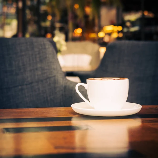 Hot latte coffee in white cup on table in restaurant and cafe — Stock Photo, Image